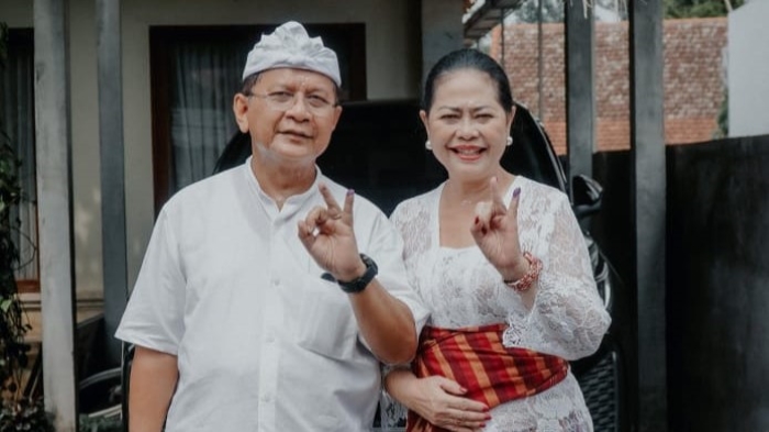 NYOBLOS: Nyoman Sutjidra (kiri) dan istrinya usai menyalurkan hak suara di Desa Bontihing.
