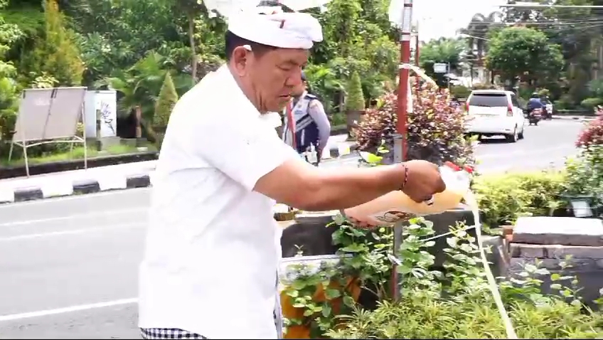 BAYAR KAUL: Mantan Camat Kubutambahan, Made Suyasa bayar kaul dengan metabuh tuak di Tugu Singa Ambara Raja.