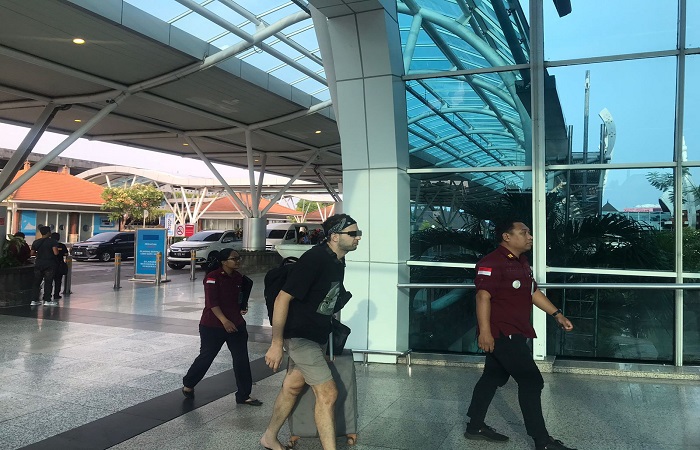 Seorang pria WN Maroko berinisial EA, 31, dikawal ketat petugas di Bandara I Gusti Ngurah Rai. Dia dideportasi ke negaranya.