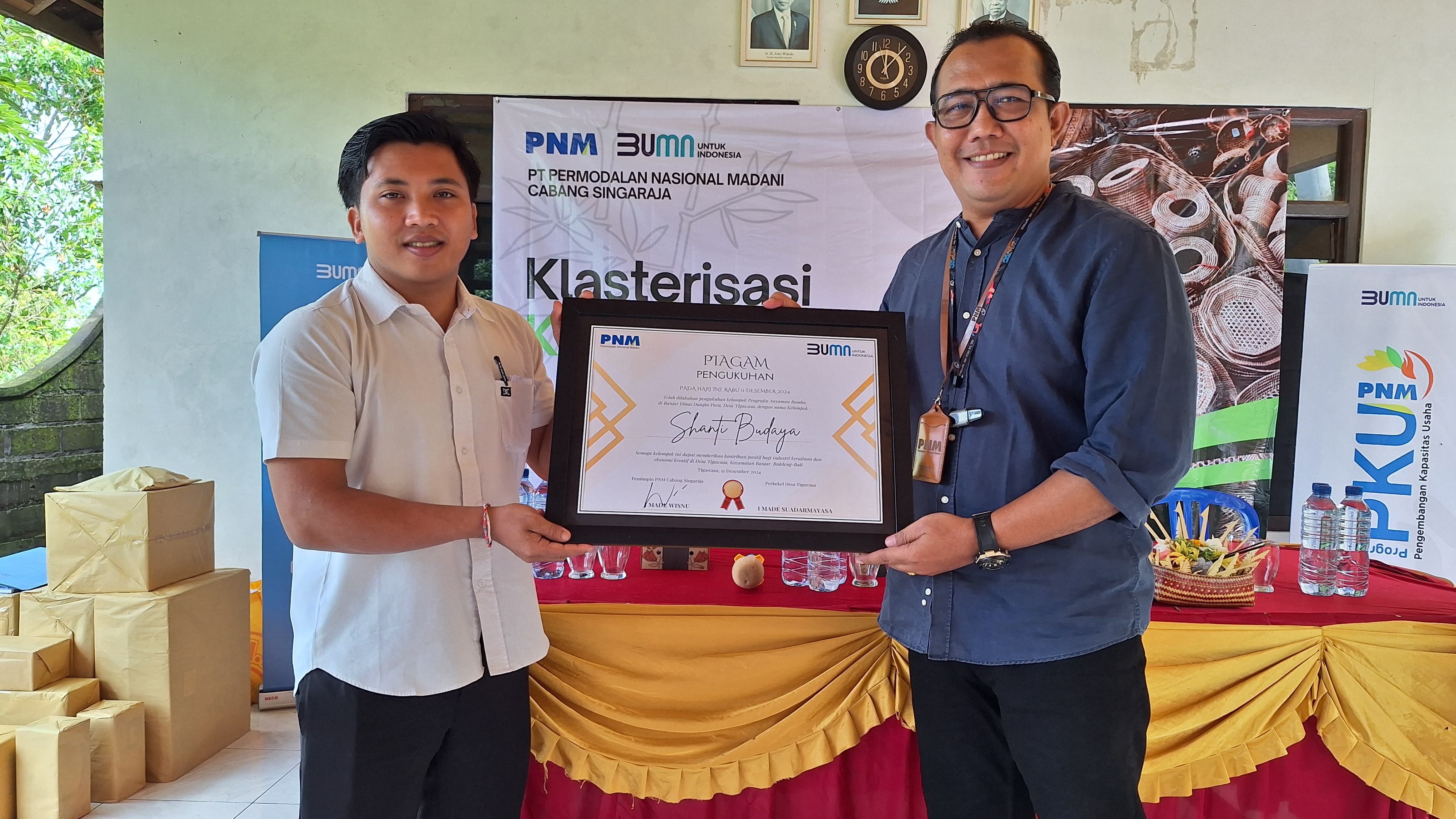 SERAHKAN BANTUAN: Pemimpin PNM Cabang Singaraja, I Made Wisnu, menyerahkan bantuan alat coating kepada perajin bambu di Desa Tigawasa, Buleleng.