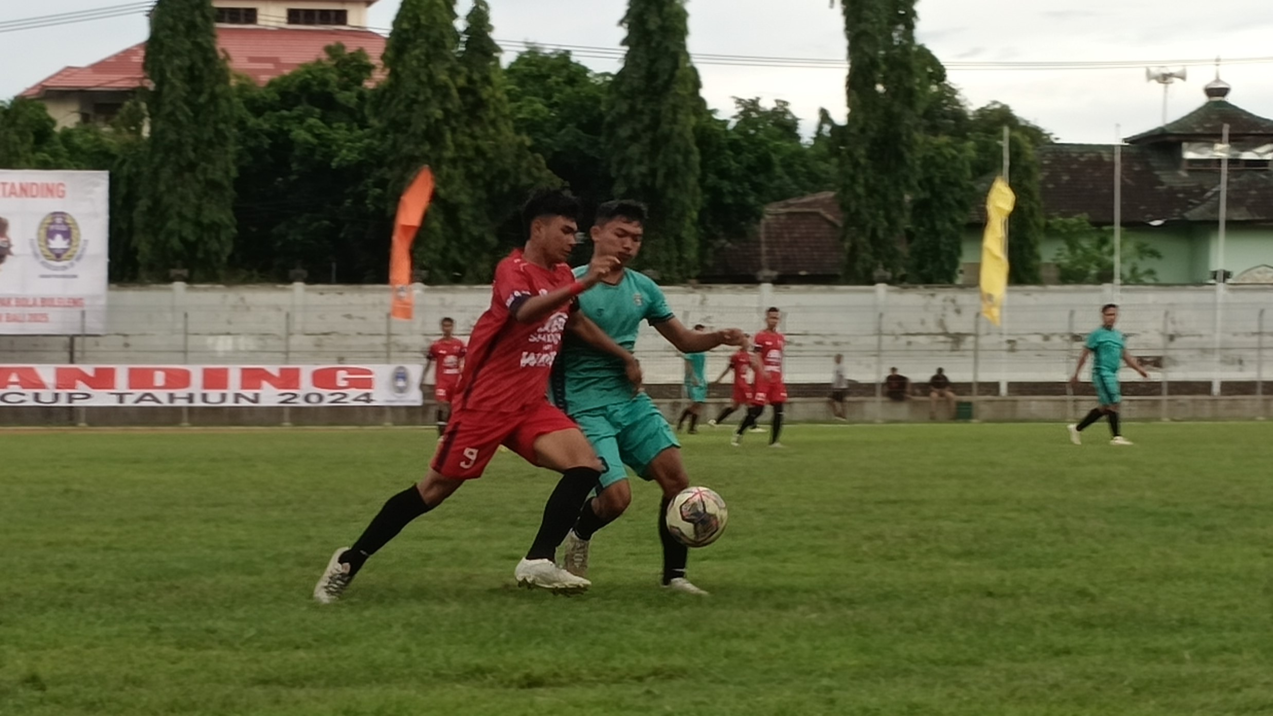 KETAT: Suasana pertandingan antara Intan Jaya FC Celukan Bawang (baju merah) dan Putra Devata Pakisan (baju hijau) pada Turnamen Sepakbola Buleleng Cup.