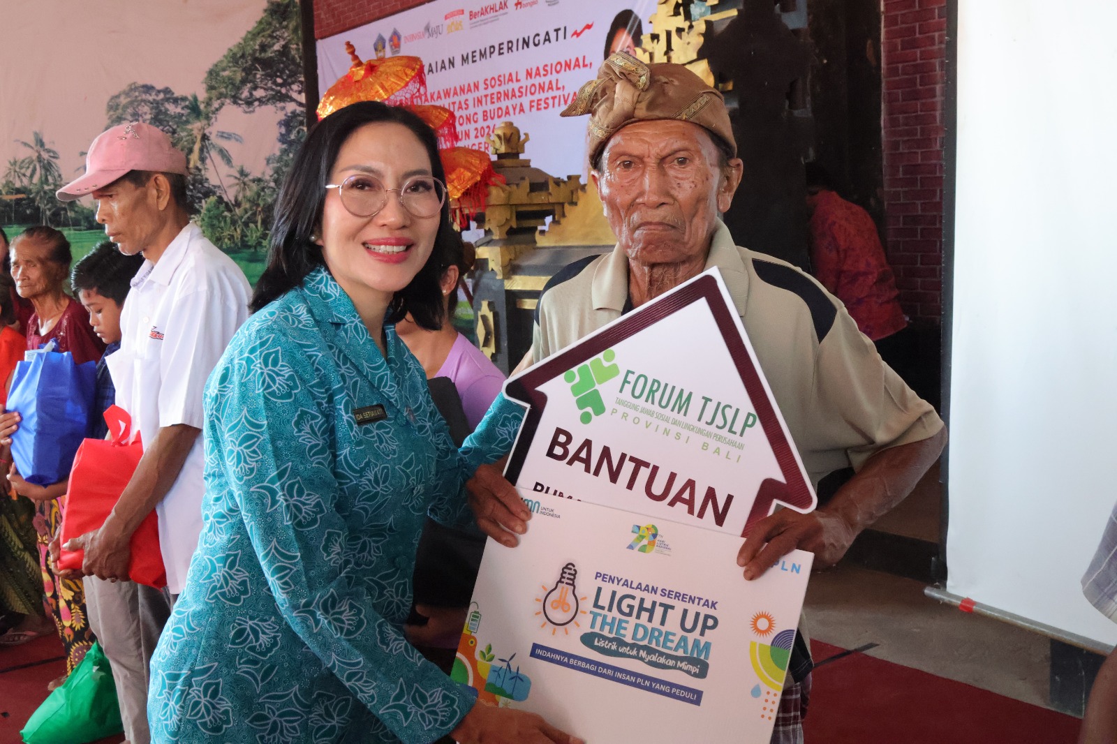 SERAHKAN BANTUAN: Ketua Tim Penggerak PKK Bali, Ny. Ida Mahendra Jaya menyerahkan bantuan kepada warga miskin di Buleleng.