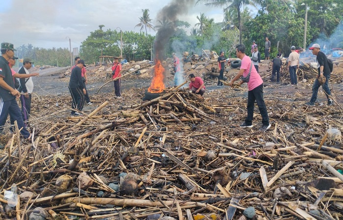 Sampah kiriman berupa bambu, ranting dan batang kayu menumpuk di Pantai Soka, Selemadeg Tabanan.