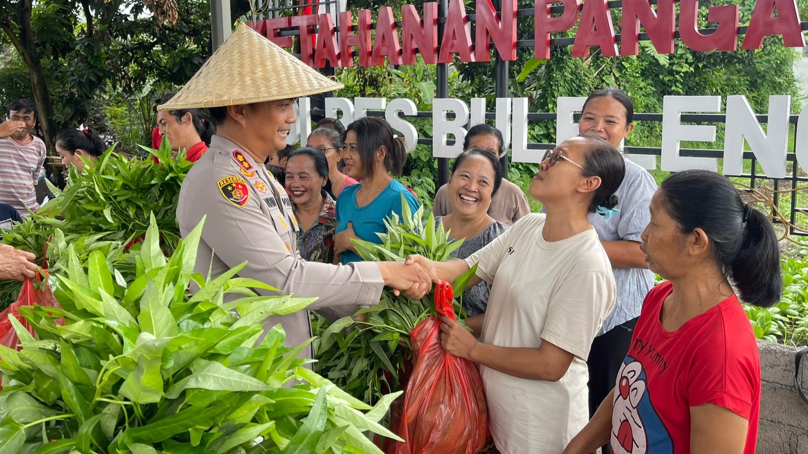 PANEN SAYUR: Kapolres Buleleng, AKBP Ida Bagus Widwan Sutadi membagikan sayur kepada warga di Desa Sambangan.