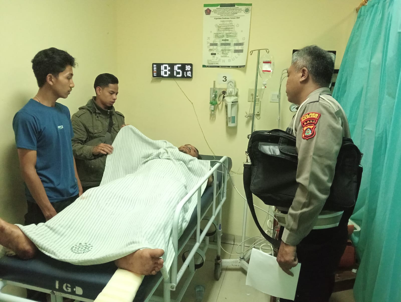 CEK KORBAN: Polisi mengecek korban luka-luka dalam peristiwa kecelakaan tunggal di Jalan Raya Denpasar-Singaraja.