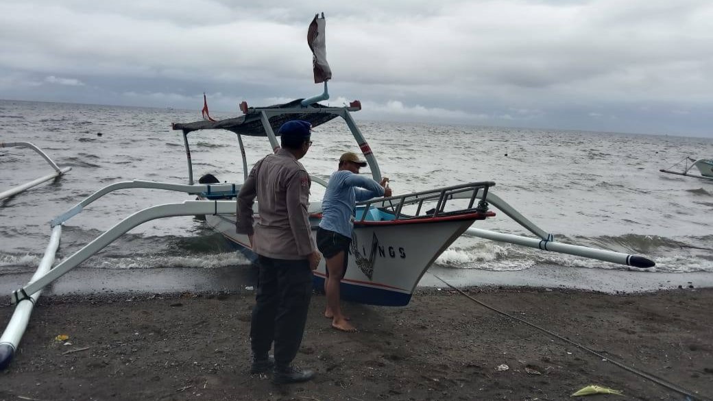 GELOMBANG PASANG: Aktivitas nelayan di Buleleng. Para nelayan telah memindahkan perahu mereka karena cuaca buruk dan gelombang pasang.
