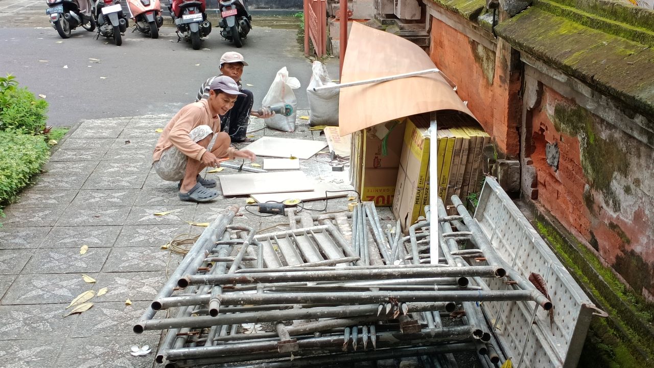 REHAB RUANG KERJA: Sejumlah buruh tampak memotong keramik untuk rehab ruang kerja bupati dan wakil bupati Buleleng.
