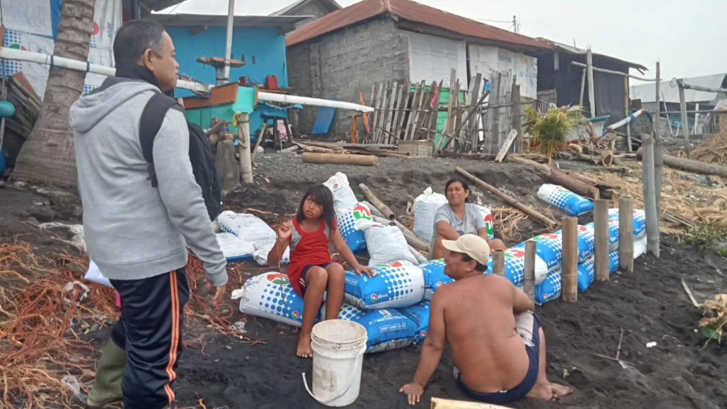 PASANG TANGGUL: Warga di pesisir pantai Desa Kubutambahan membuat tanggul. Harapannya tanggul dapat menahan gelombang pasang yang merusak rumah warga.
