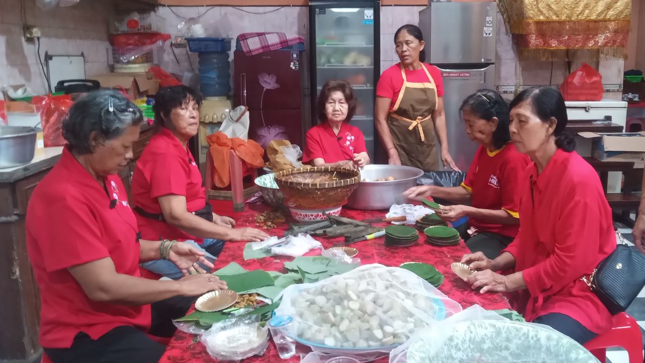 HIDANGAN WAJIB: Wanita di Kongco Bio/Vihara Dharma Cattra menyiapkan lontong cap go meh.