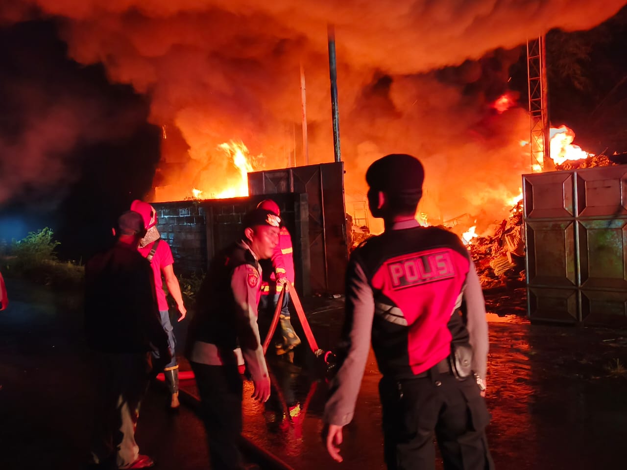 KEBAKARAN: Aparat kepolisian dari Polres Klungkung dan petugas pemadam kebakaran dari Klungkung dan Gianyar bahu membahu memadamkan api yang membakar gudang rongsokan.