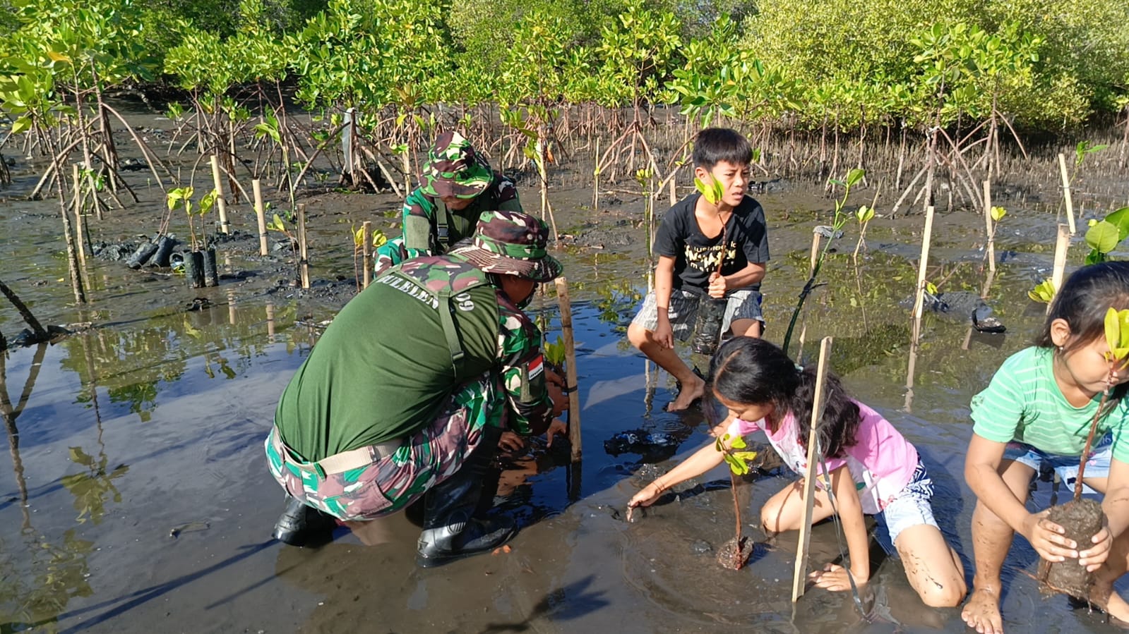 TANAM MANGROVE: TNI bersama anak-anak di Desa Sumberklampok melakukan penanaman mangrove di Teluk Terima.