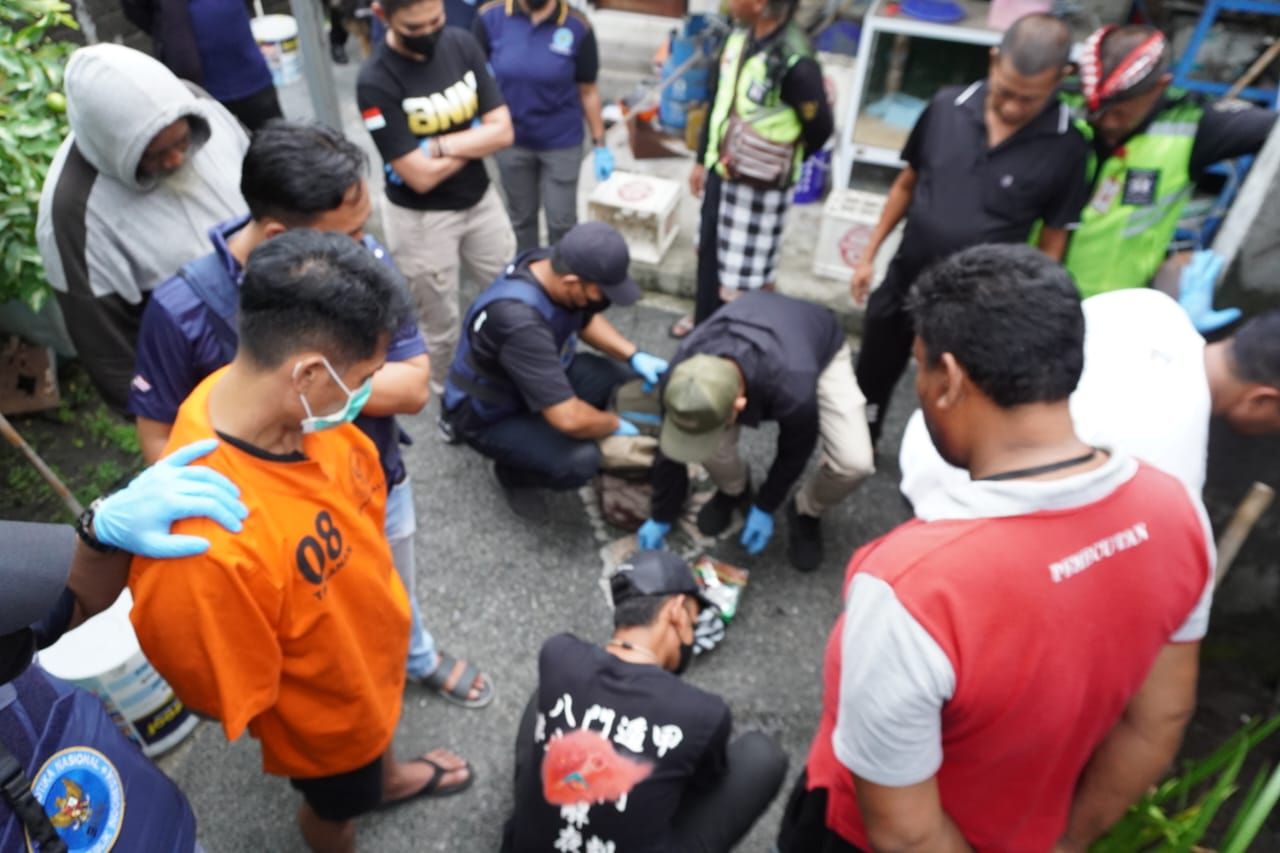 GELEDAH: Tim BNN Provinsi Bali saat menggeledah rumah tersangka SP. Aparat menemukan narkoba dengan berta 1,4 kilogram yang dikubur di halaman rumah.