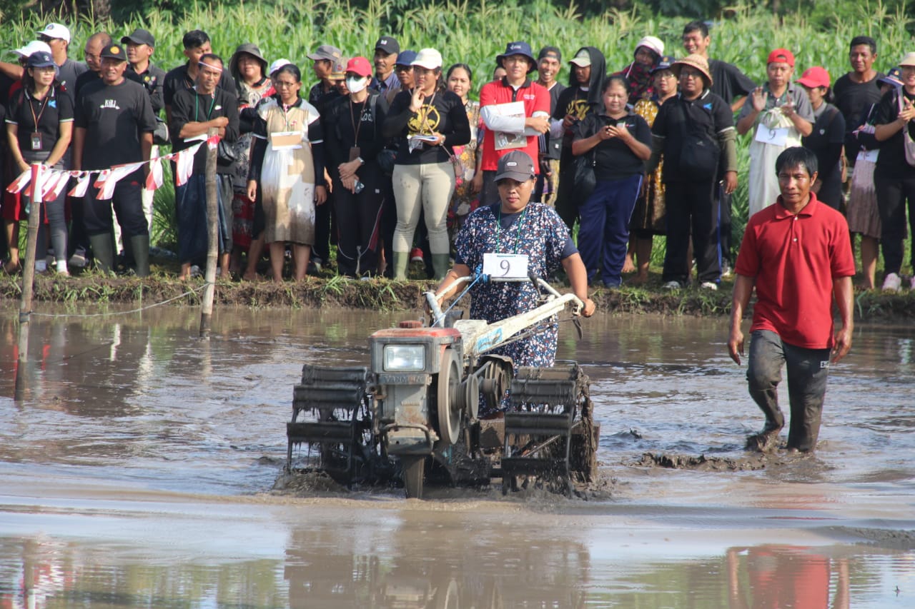 BALAP TRAKTOR: Salah seorang ibu yang juga penyuluh pertanian, mengikuti lomba balap traktor yang digelar Dinas Pertanian Buleleng.