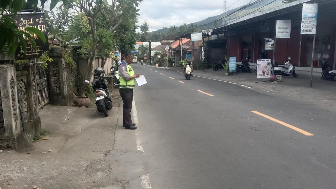 OLAH TKP: Aparat kepolisian melakukan olah TKP di Jalan Raya Singaraja-Amlapura, Kecamatan Tejakula. Kecelakaan mengakibatkan seorang ibu mengalami luka serius, hingga tak sadarkan diri.