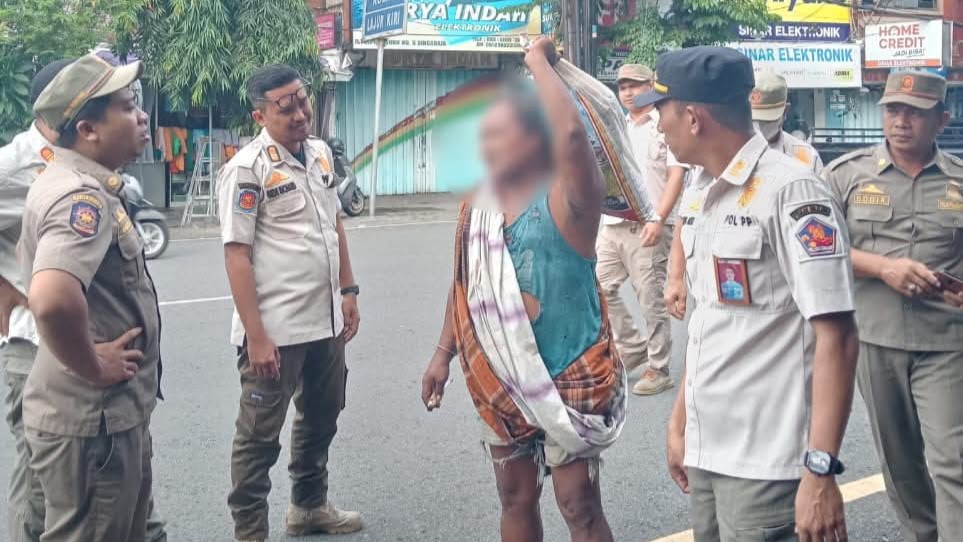 AMANKAN: Pol PP Buleleng mengamankan seorang ODGJ yang terlihat berjalan di ruas Jalan Diponegoro, Singaraja.