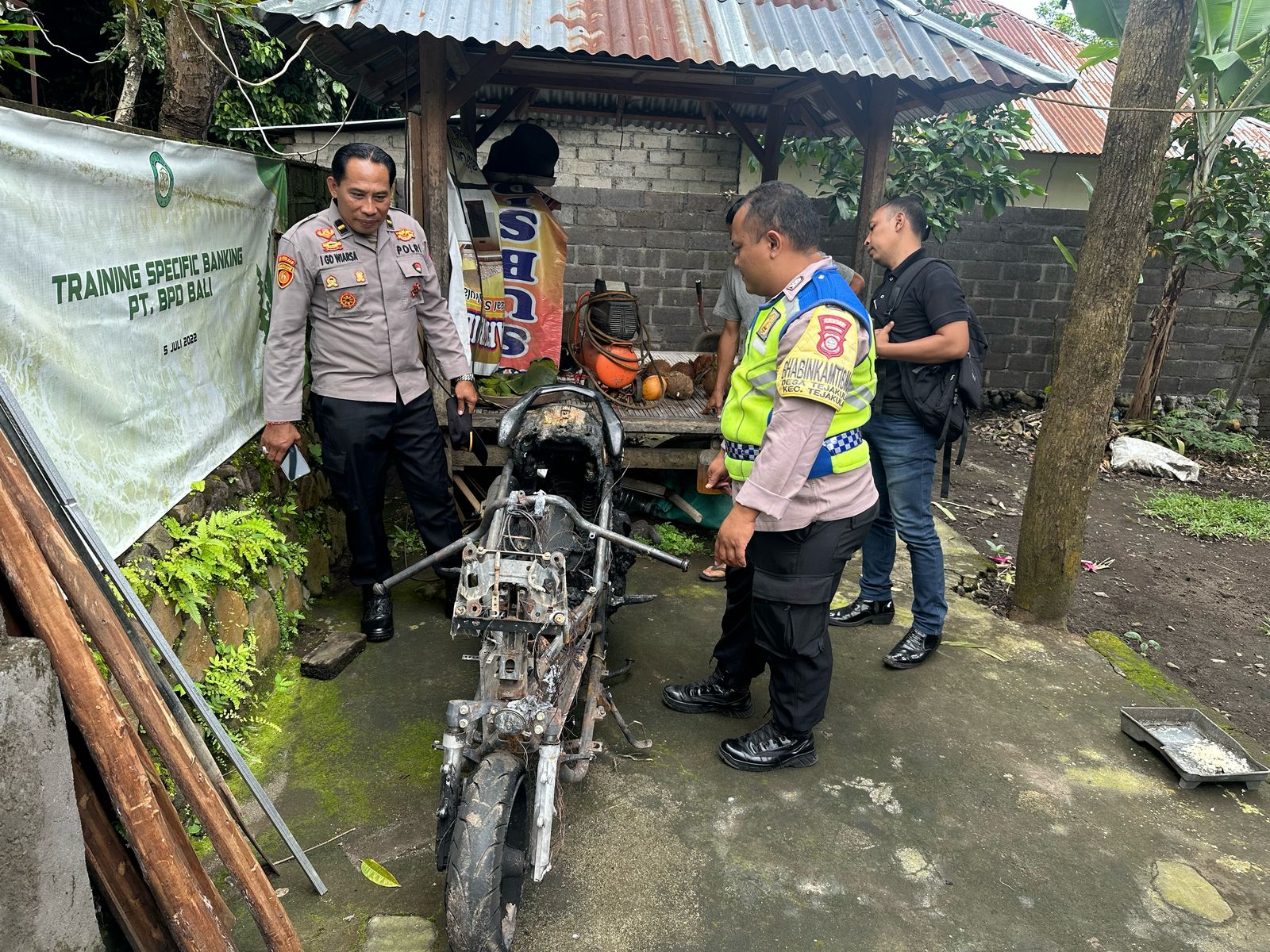 CEK LOKASI: Aparat kepolisian dari Polsek Tejakula mendatangi lokasi kejadian sepeda motor yang terbakar.