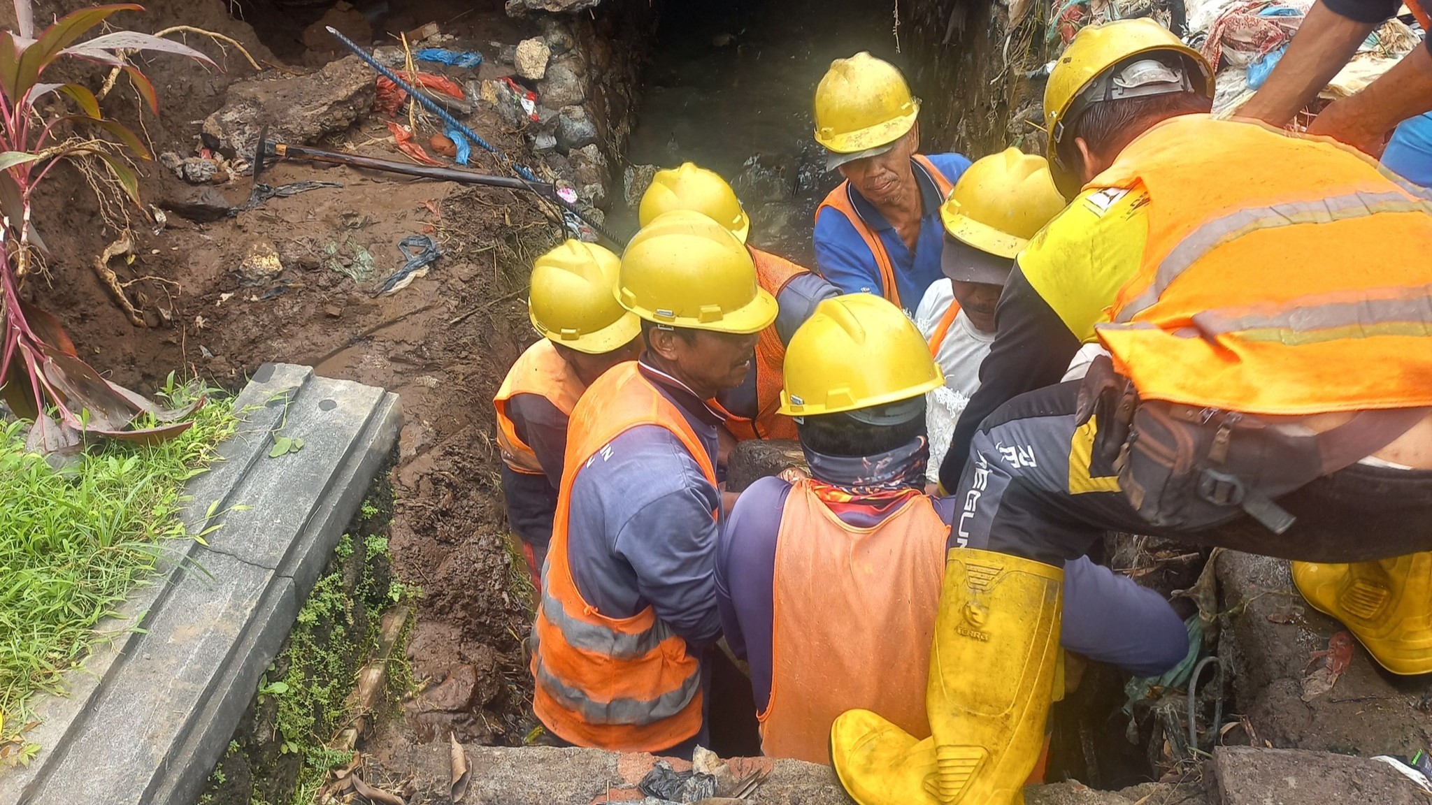 BERSIHKAN DRAINASE: Tim drainase Dinas PUTR Buleleng melakukan pembersihan sampah di saluran drainase Jalan Raya Jelantik Gingsir, Buleleng.