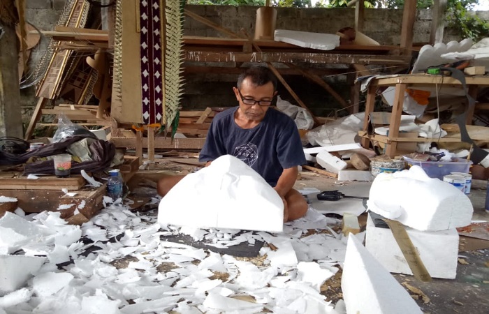 Ida Ketut Santosa saat mengerjakan pesanan tapel ogoh-ogoh, Selasa (18/3) kemarin.