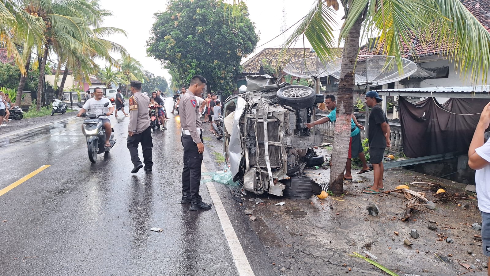 TERGULING: Mobil yang terguling di Jalan Raya Singaraja-Gilimanuk. Akibat peristiwa itu, pengemudi mobil mengalami luka parah.