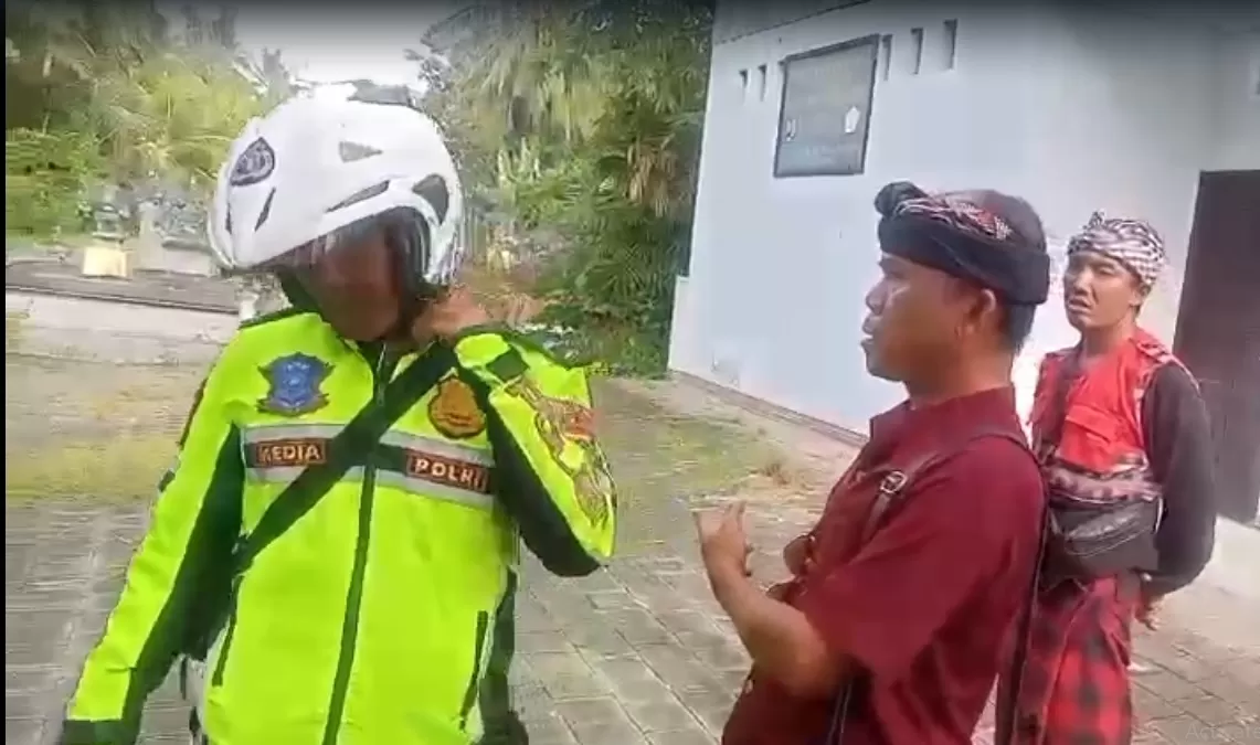 SEMPAT ADU MULUT: Oknum polisi berinisial MC saat dihentikan oleh pecalang Desa Adat Sumbersari.