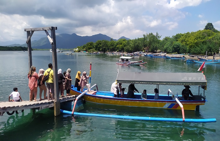 Wisatawan menggunakan jasa perahu untuk keliling pulau-pulau kecil di sekitar Teluk Gilimanuk.