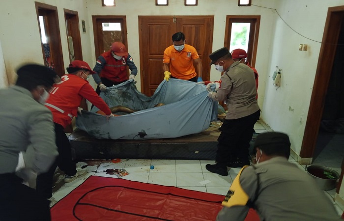 Petugas mengevakuasi jenazah Gusti Surya setelah ditemukan tak bernyawa di dalam rumahnya.