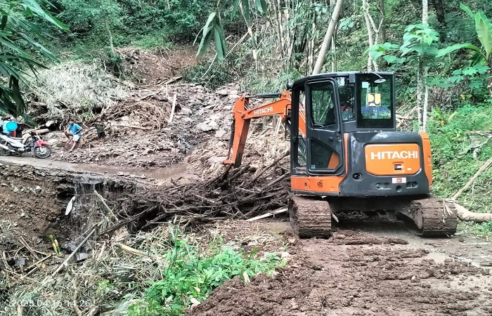 Petugas saat melakukan penanganan pembersihan material longsor yang menutup akses jalan warga di Jalan lingkungan Pekarangan.