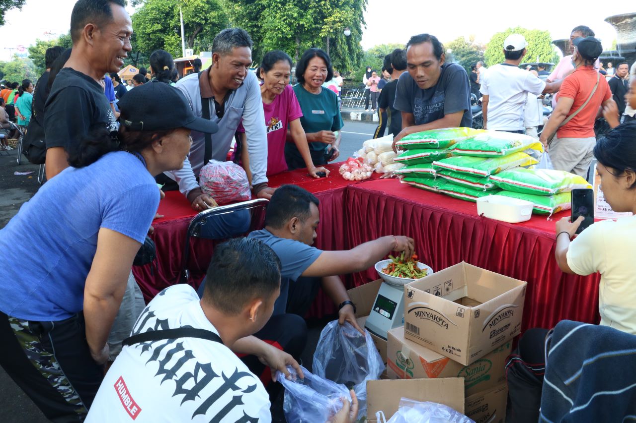 TIMBANG DULU: Warga menanti petugas stand pasar murah menimbang cabai rawit. Komoditas cabai paling dicari.