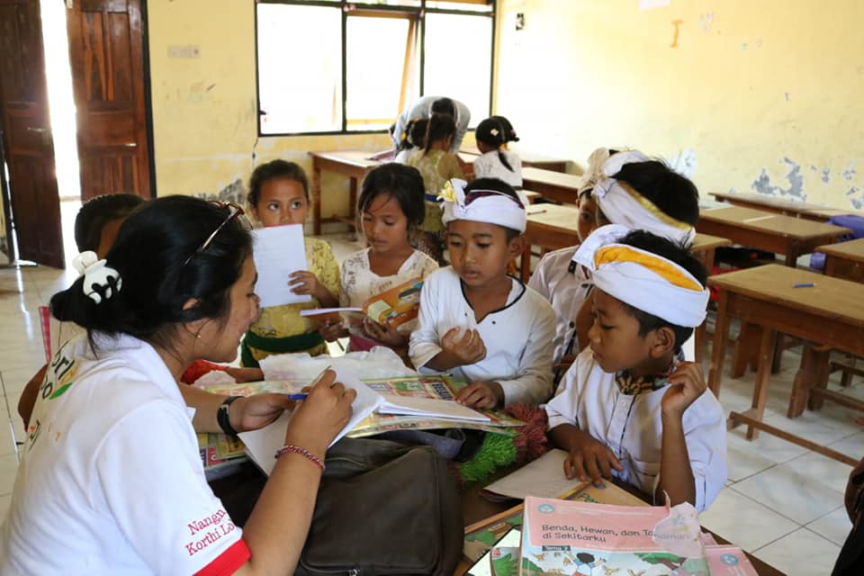 BELAJAR MEMBACA: Mahasiswa Hindu yang tergabung di KMHDI Buleleng saat menggelar program KMHDI Mengajar di Desa Pejarakan beberapa waktu lalu.