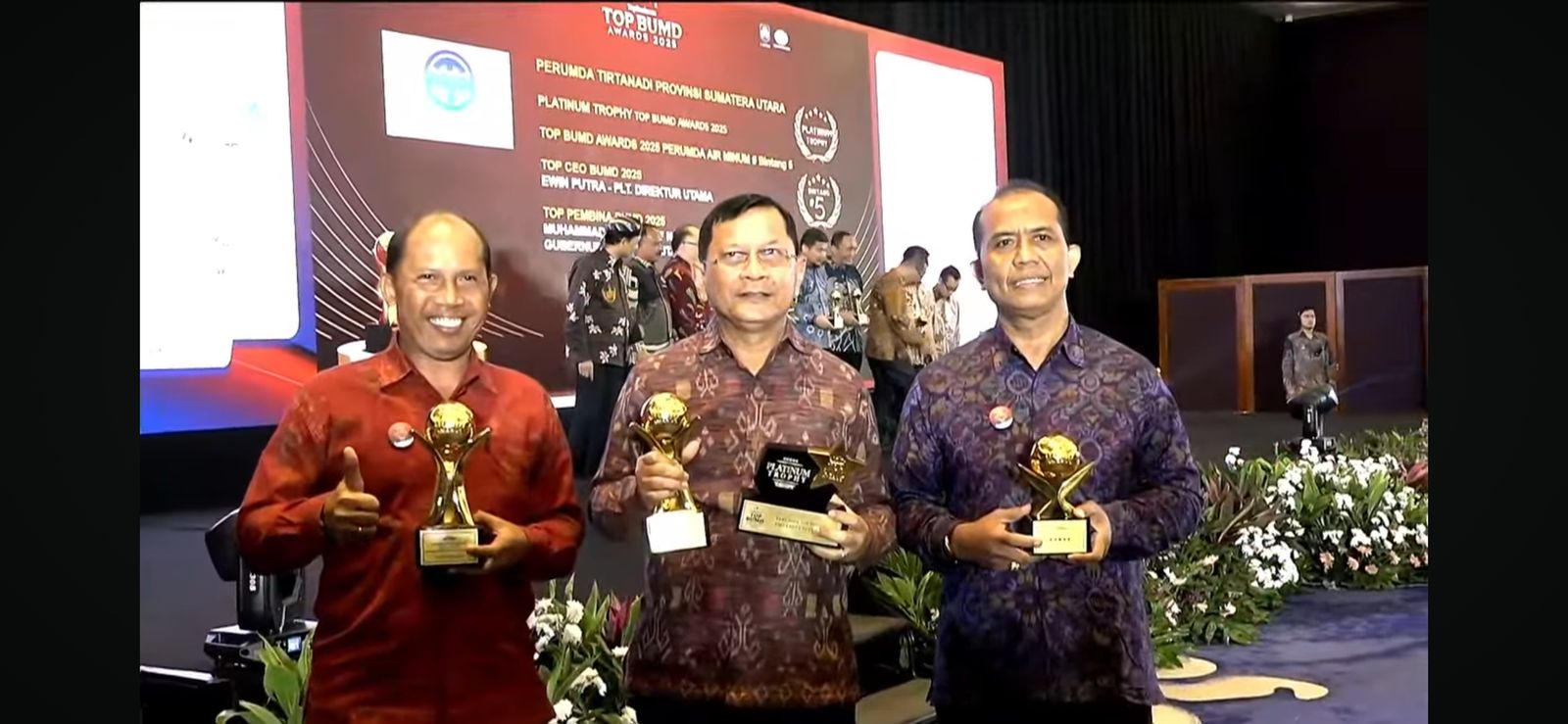 RAIH PENGHARGAAN: Bupati Buleleng, I Nyoman Sutjidra (tengah) dan Direktur Perumda Tirta Hita Buleleng (kiri) menerima penghargaan Top BUMD.