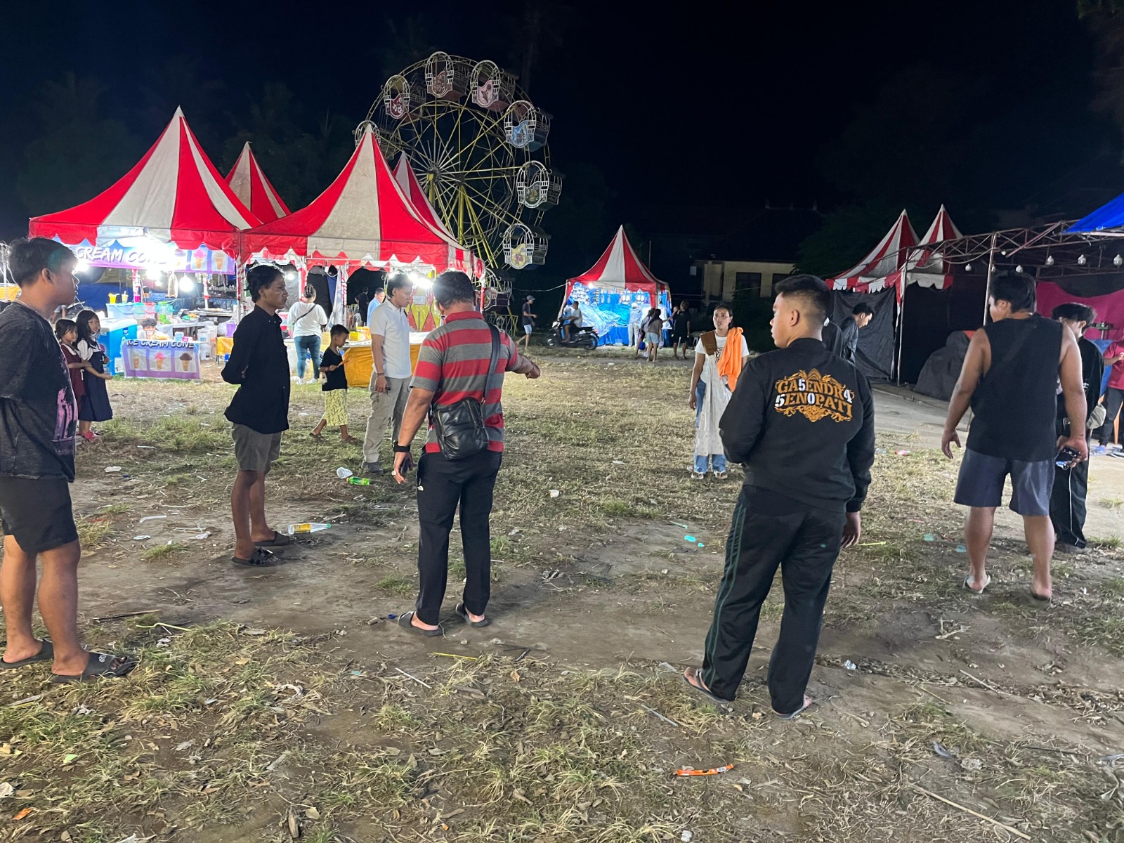 CEK TKP: Aparat kepolisian melakukan pengecekan TKP di Pasar Malam Nusa Penida. Seorang warga mengalami luka akibat tusukan sajam.