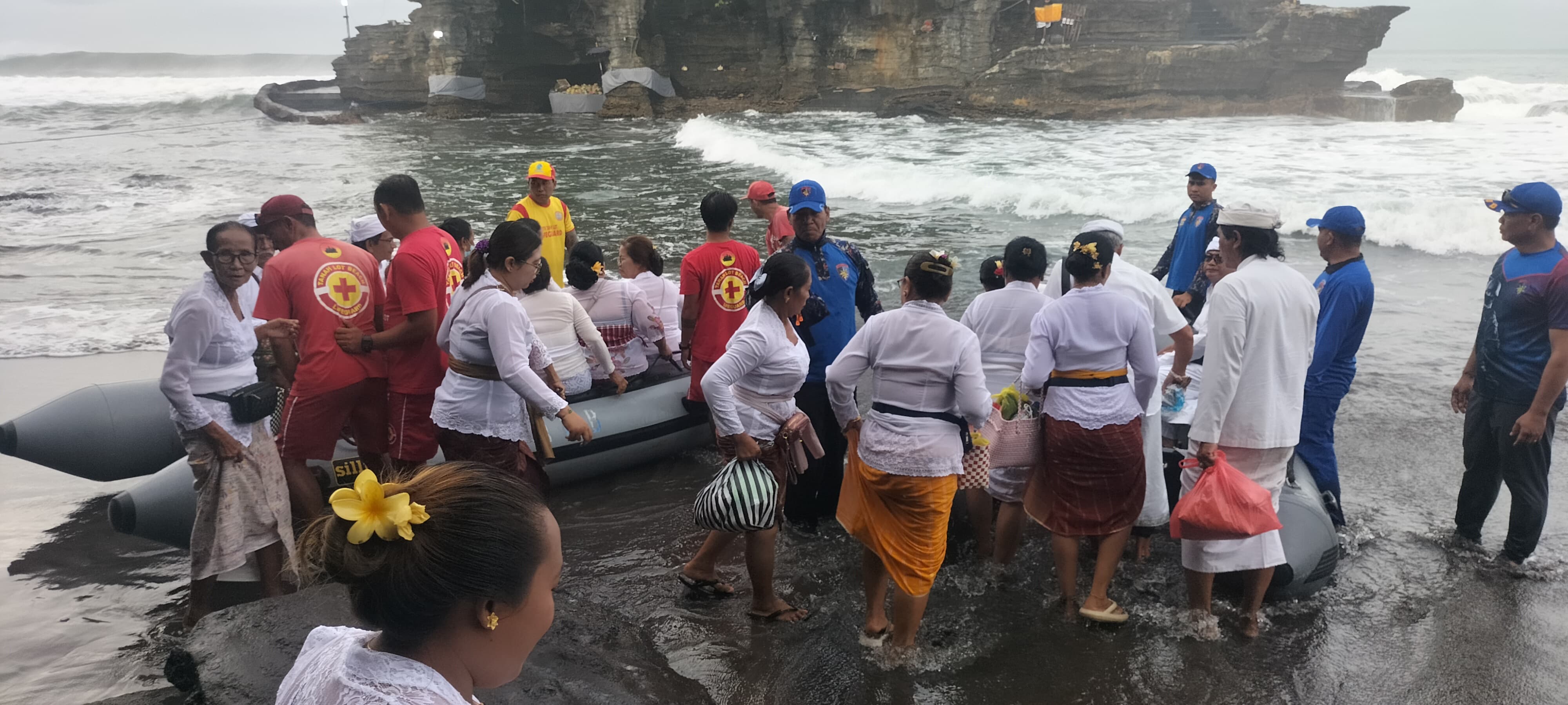 DEMI KESELAMATAN: Pemedek Pura Tanah Lot menyeberangi laut dengan menggunakan perahu karet.