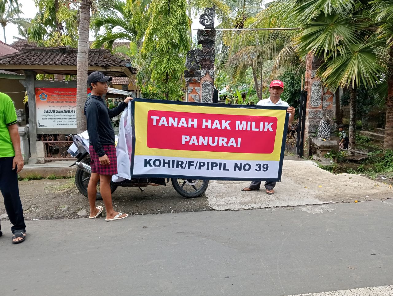 KLAIM LAHAN: Pemasangan spanduk di depan SDN 2 Sambangan, Buleleng.
