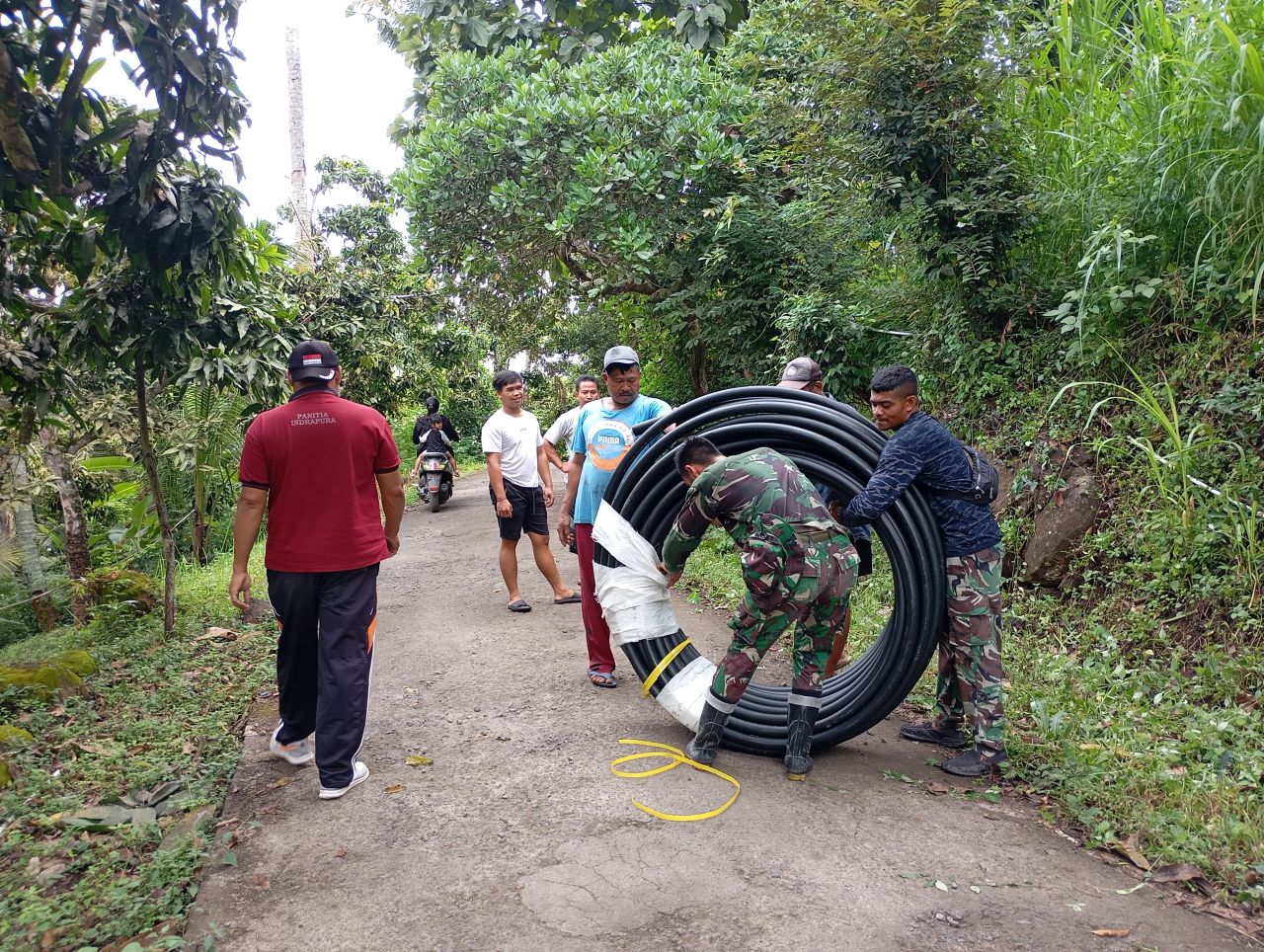 PASANG PIPA: Personel TNI memasang pipa air bersih. Pipa akan menyalurkan air bersih dari reservoar di Banjar Dinas Dangin Pura, Desa Depeha.