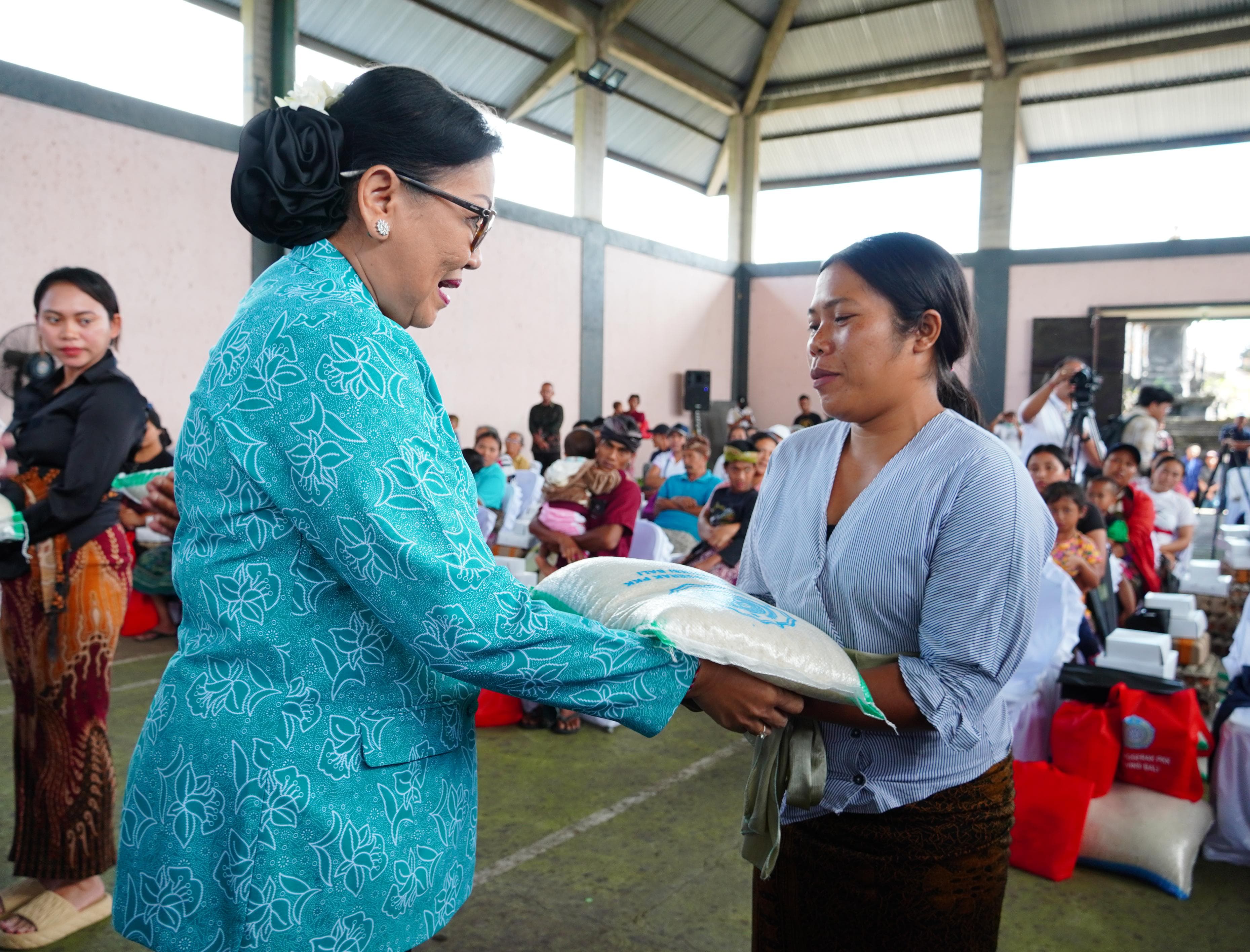SERAHKAN BANTUAN: Ketua TP PKK Provinsi Bali, Ny. Putri Suastini Koster (kiri) menyerahkan bantuan kepada warga di Desa Madenan, Buleleng.