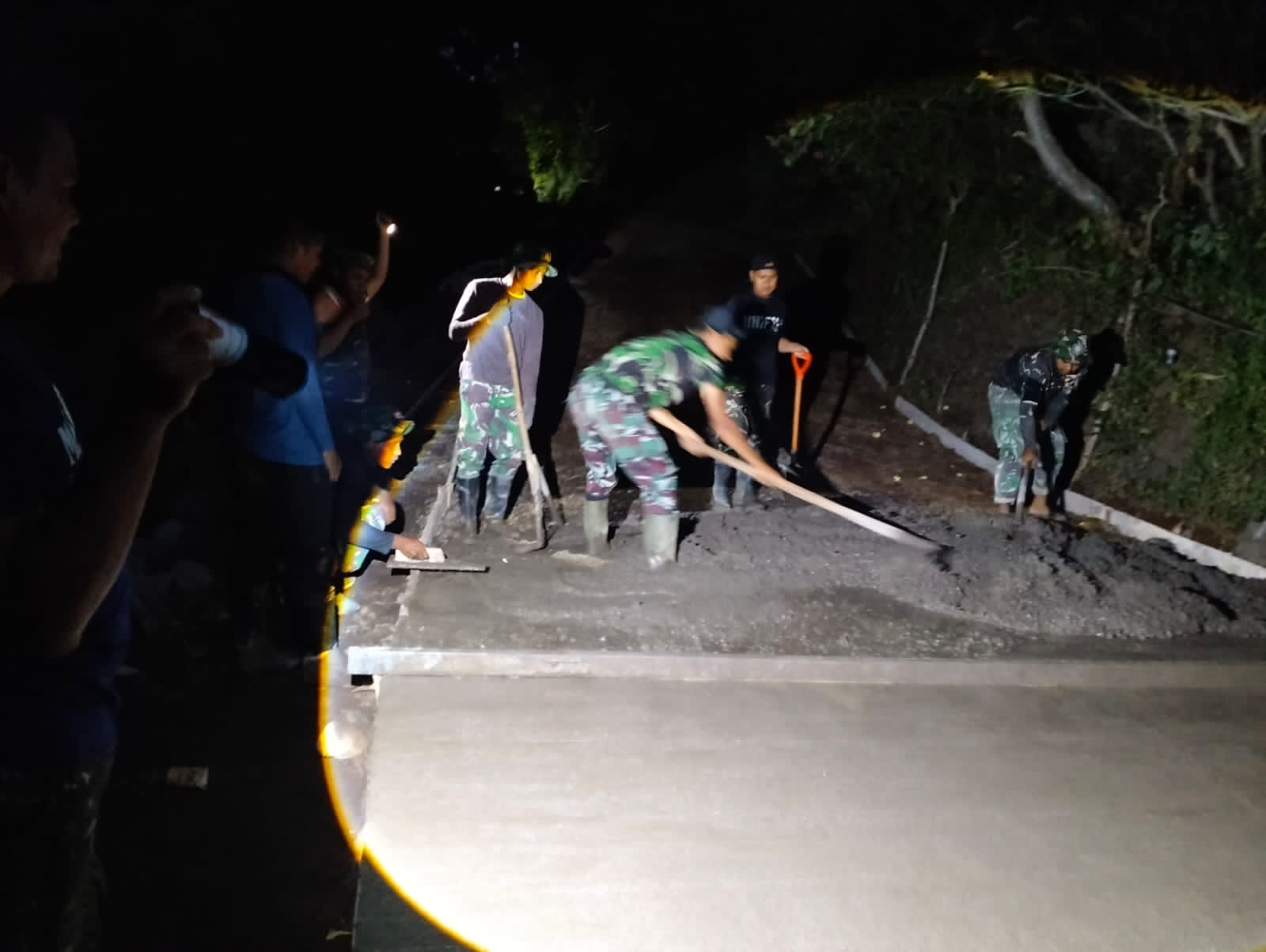 TMMD: Personel TNI melakukan pengecoran jalan hingga malam hari, untuk mempercepat pekerjaan TMMD.