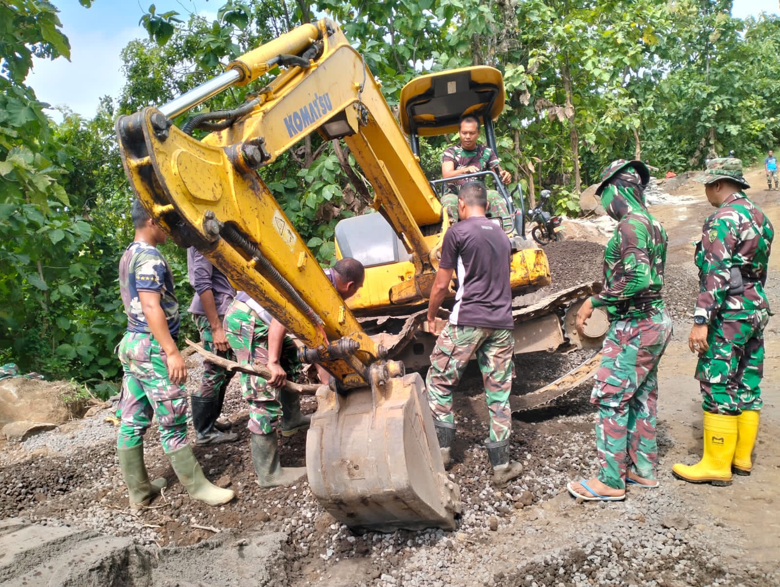 TMMD BULELENG: Personel TNI melakukan perbaikan excavator yang rusak.