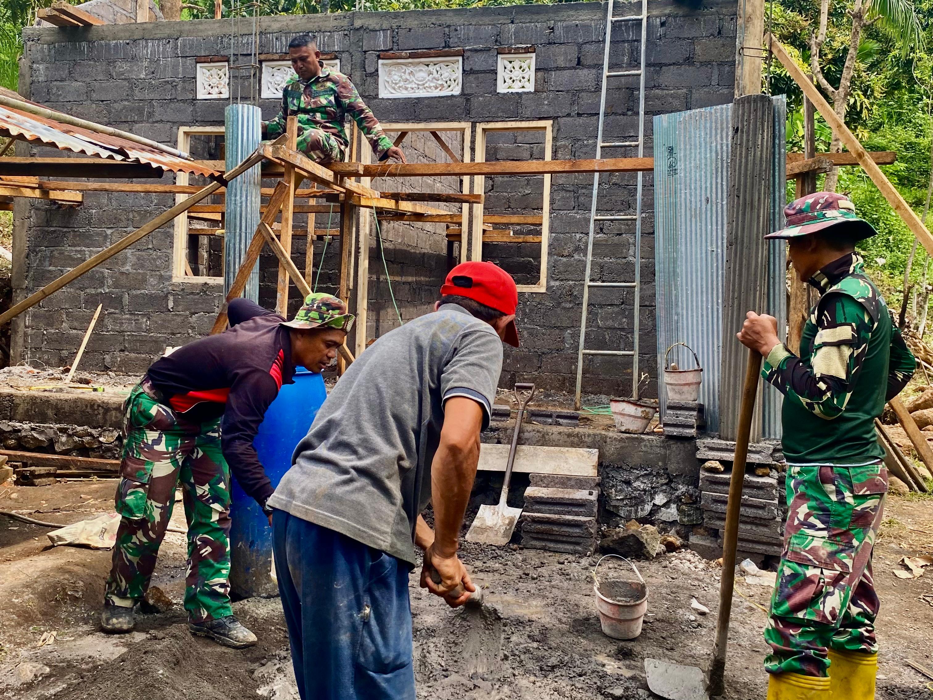 GOTONG ROYONG: Personel TNI bergotong royong membantu Gede Kandia membangun rumah impian.