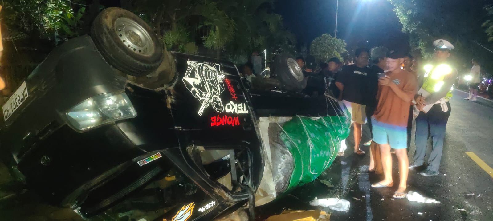TERGULING: Mobil pick up terguling di jalan raya gara-gara ban mobil meledak.