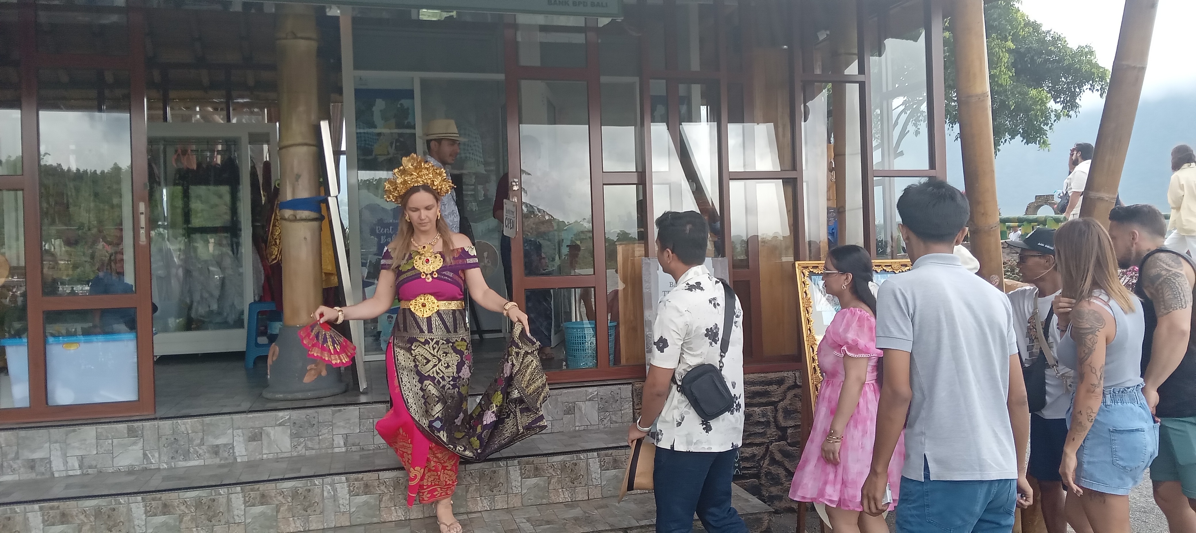 PAKAIAN ADAT: Salah seorang wisatawan tampak keluar dari stand penyewaan pakaian adat Bali di objek wisata Bedugul.