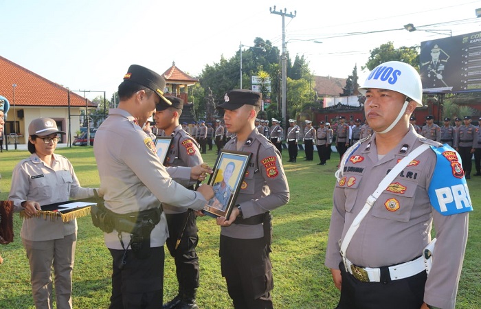 Kapolres Buleleng, AKBP Ida Bagus Widwan Sutadi mencoret foto dua personelnya, sebagai simbolis resmi dipecatnya Bripka Kertayasa dan Aipda Suweta.