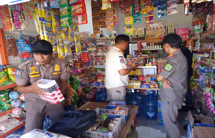Suasana tim gabungan Satpol PP Tabanan bersama Bea Cukai Denpasar saat operasi gempur rokok ilegal yang menyasar toko kelontong di Tabanan.