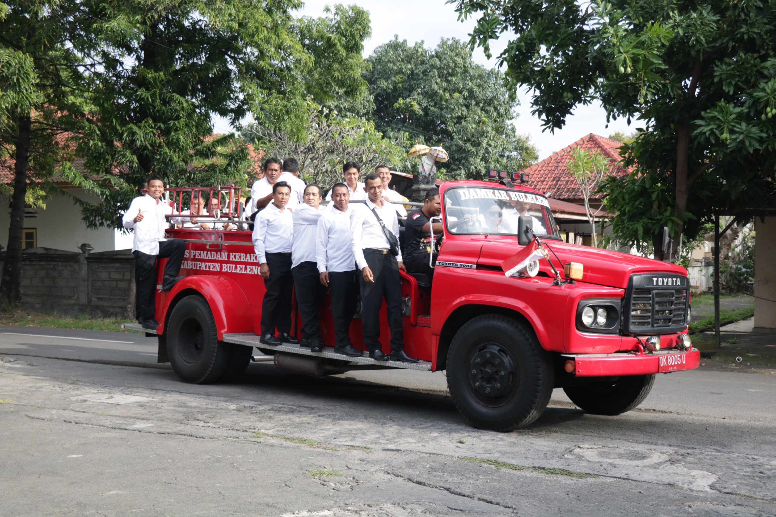 TERSENYUM: Para pegawai kontrak Dinas Pemadam Kebakaran Buleleng. Mereka menuju lokasi penerimaan SK dengan mengendarai truk pemadam kebakaran uzur.