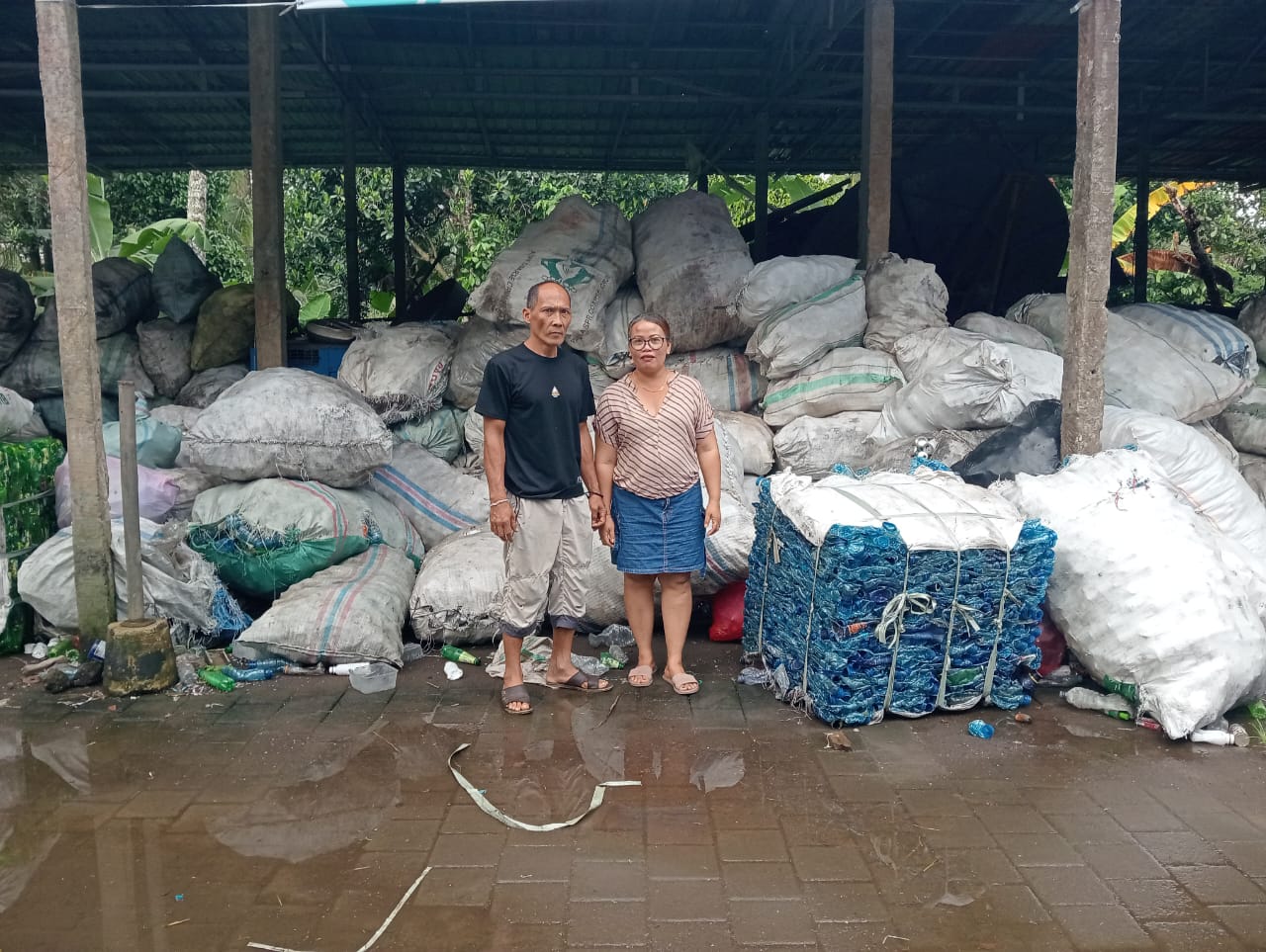 CUAN DARI SAMPAH: Ketut Arta Wijaya dan istrinya, Ni Luh Sukenadi berfoto di gudang penampungan sampah yang ada di Desa Sobangan Tengah, Mengwi.