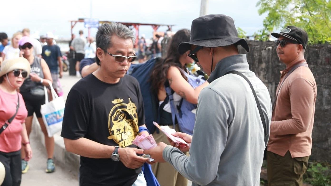 PUNGUTAN: Petugas tiket melakukan pemungutan retribusi kepada wisatawan yang berkunjung ke Nusa Penida.