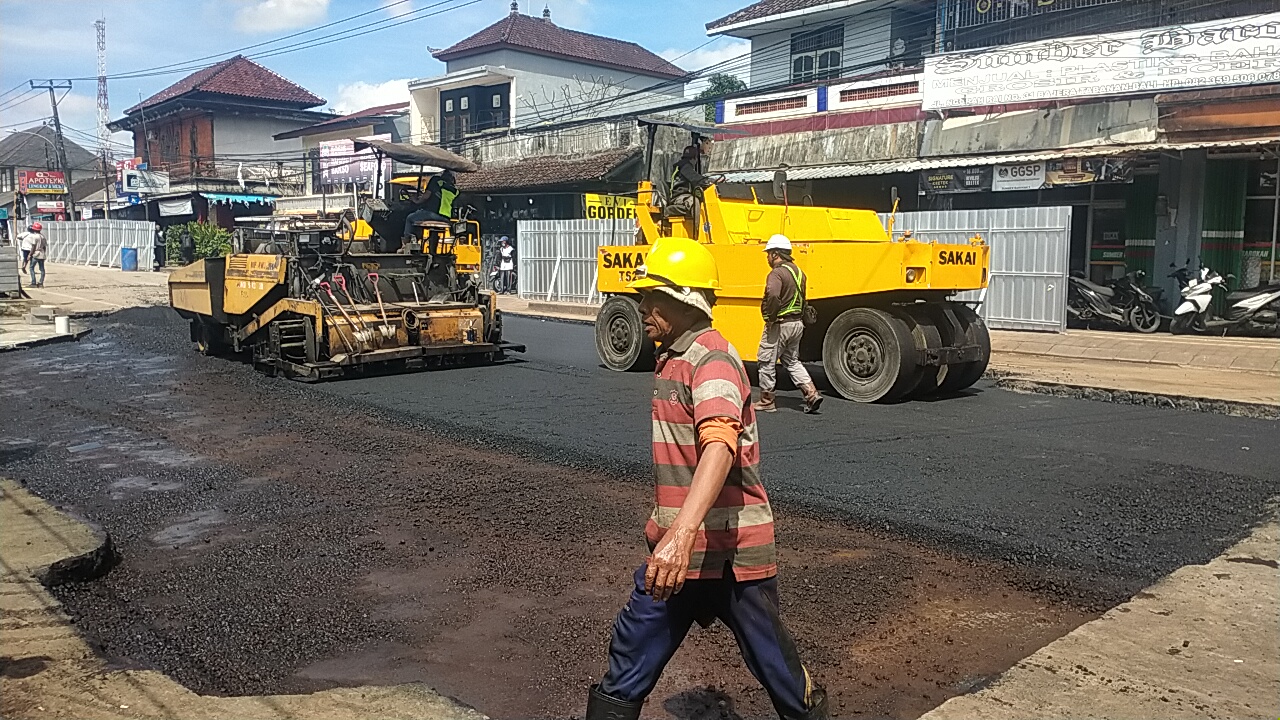 PENGASPALAN: Proses pengaspalan jalan yang amblas di Jalan Raya Denpasar-Gilimanuk. Proses uji coba akan dilakukan malam ini sebelum dibuka lagi untuk kendaraan.