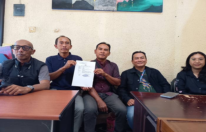 I Nengah Muliartha (dua dari kiri) dan Budiman (tiga dari kiri) menunjukkan bukti laporan ke Polres Klungkung.