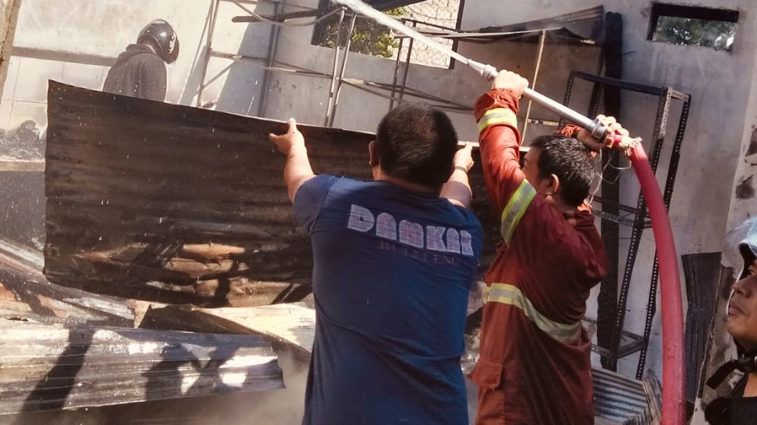 PADAMKAN API: Petugas Dinas Pemadam Kebakaran Buleleng memadamkan api yang membakar rumah warga di Padangkeling.