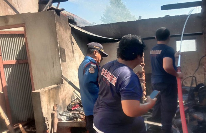 Petugas sedang melakukan pemadaman di salah satu rumah yang terbakar. Peristiwa ini terjadi, diduga karena korsleting listrik.