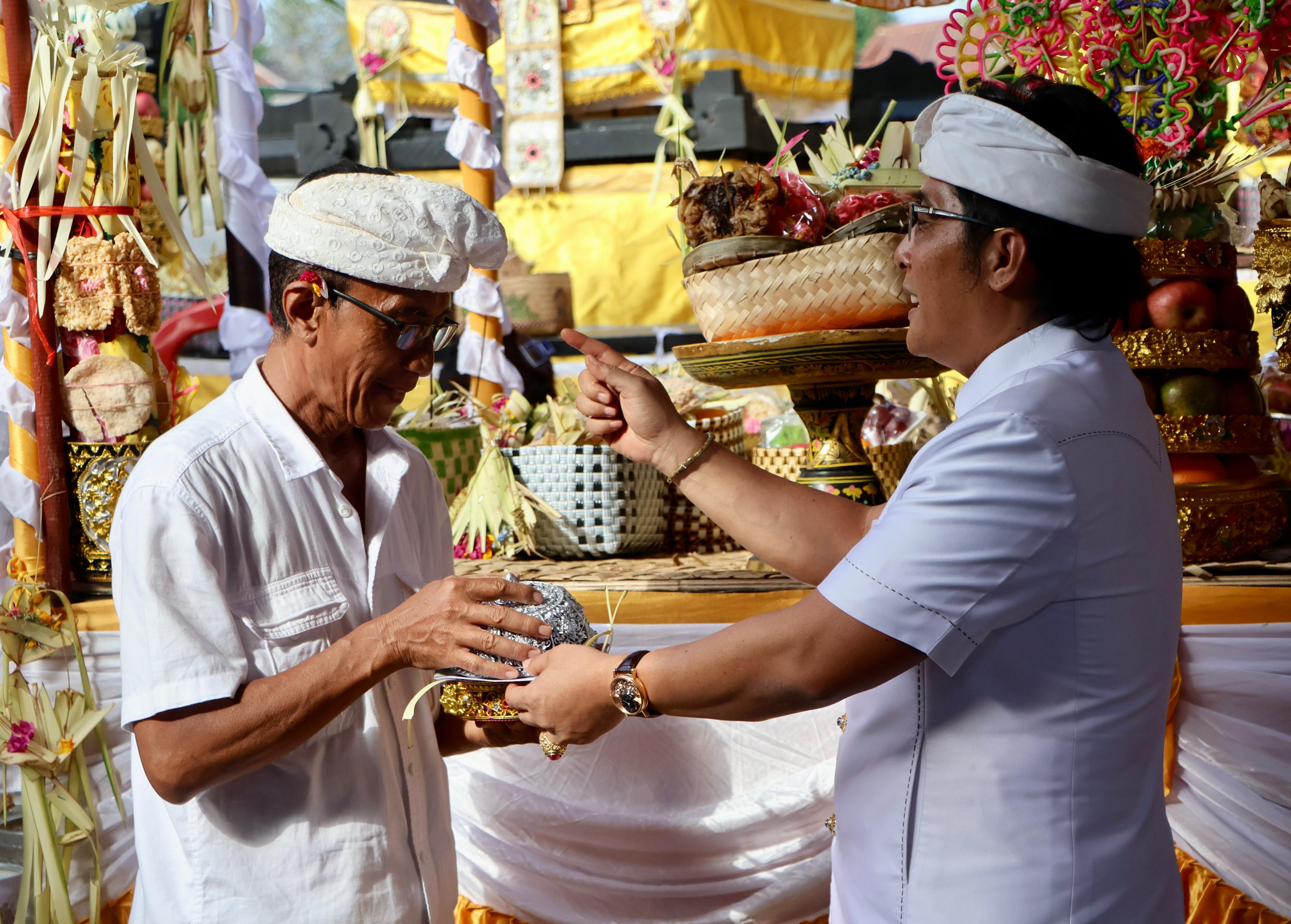 SERAHKAN PUNIA: Wakil Gubernur Bali, Nyoman  Giri Prasta (kanan) menyerahkan punia kepada krama dadia Arya Kenceng Tegeh Kori, Buleleng.